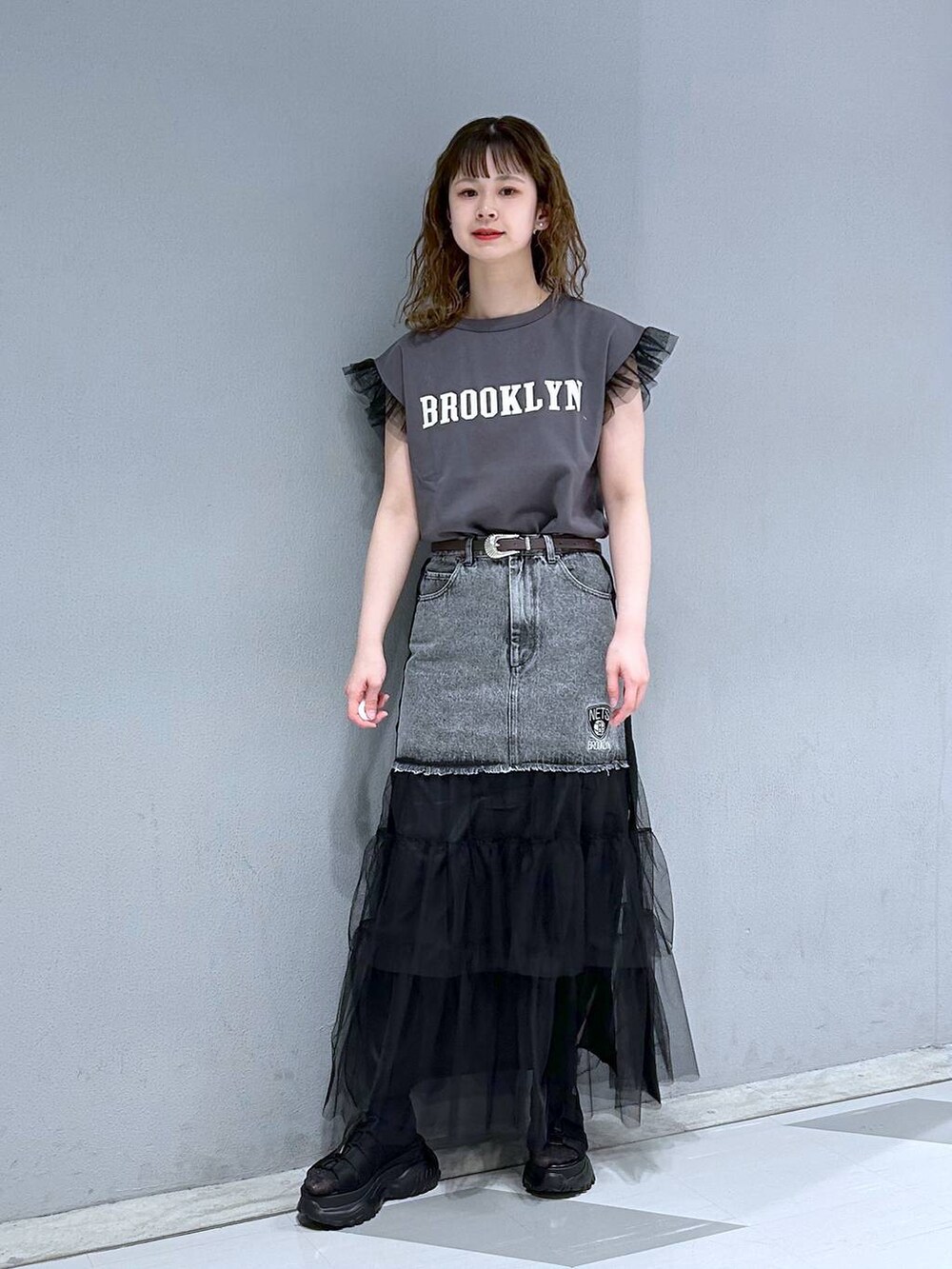 ブラック系のTシャツ/カットソー、ブラック系のデニムスカート、ブラウン系のベルトを着用したレディースの春コーディネートの4枚目の写真