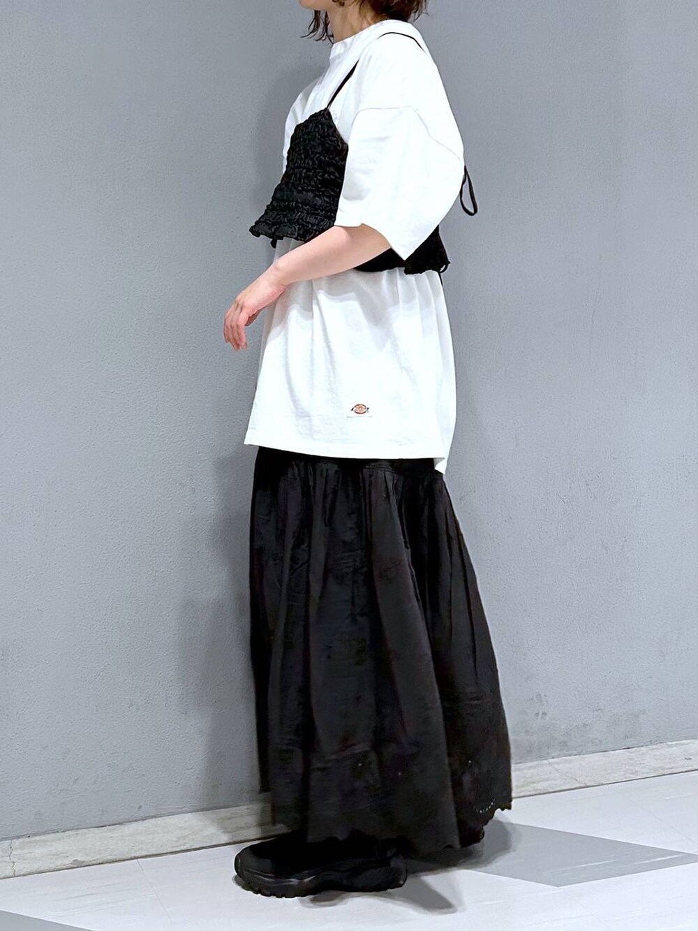 ブラック系のベスト、ホワイト系のTシャツ/カットソー、ブラック系のスカートを着用したレディースの夏コーディネートの2枚目の写真