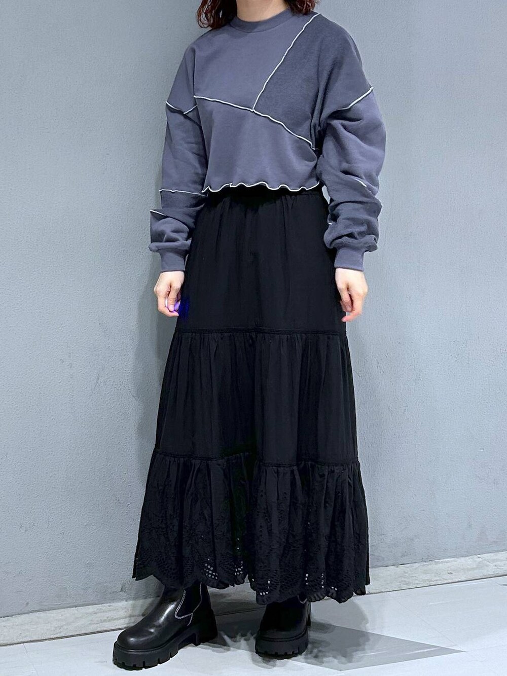 ブルー系のスウェット、ブラック系のスカート、ブラウン系のブルゾンを着用したレディースの冬コーディネートの2枚目の写真