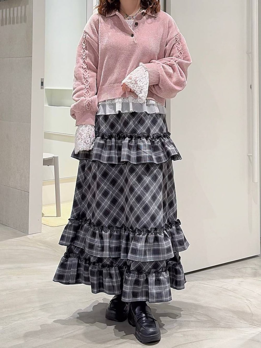 ピンク系のニット/セーター、ホワイト系のTシャツ/カットソー、ブラック系のスカートを着用したレディースの秋コーディネートの2枚目の写真