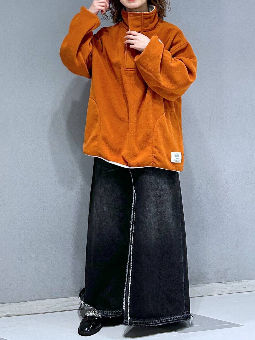 ブラック系のデニムスカート、オレンジ系のスウェットを着用したレディースの秋コーディネートの2枚目の写真