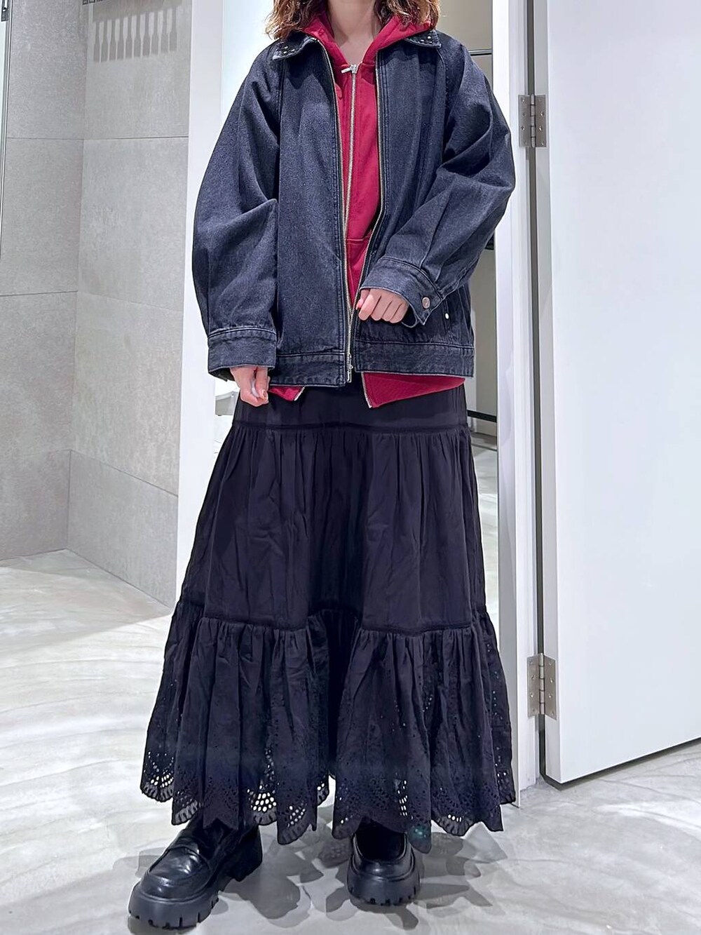 ブラック系のローファー、ブラック系のブルゾン、レッド系のパーカーを着用したレディースの秋コーディネートの2枚目の写真