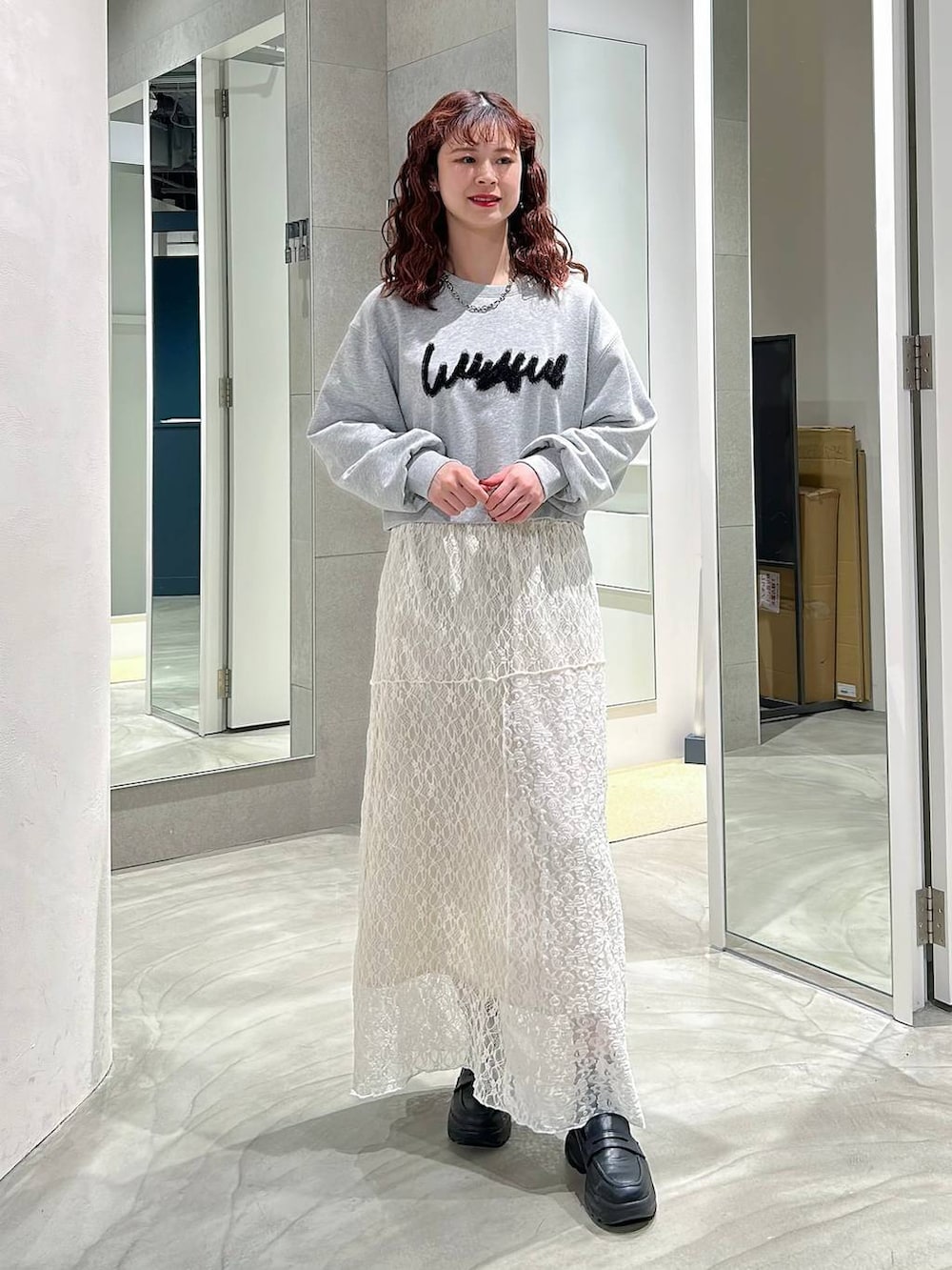 ブラック系のローファー、ホワイト系のスカート、グレー系のスウェットを着用したレディースの春コーディネートの4枚目の写真