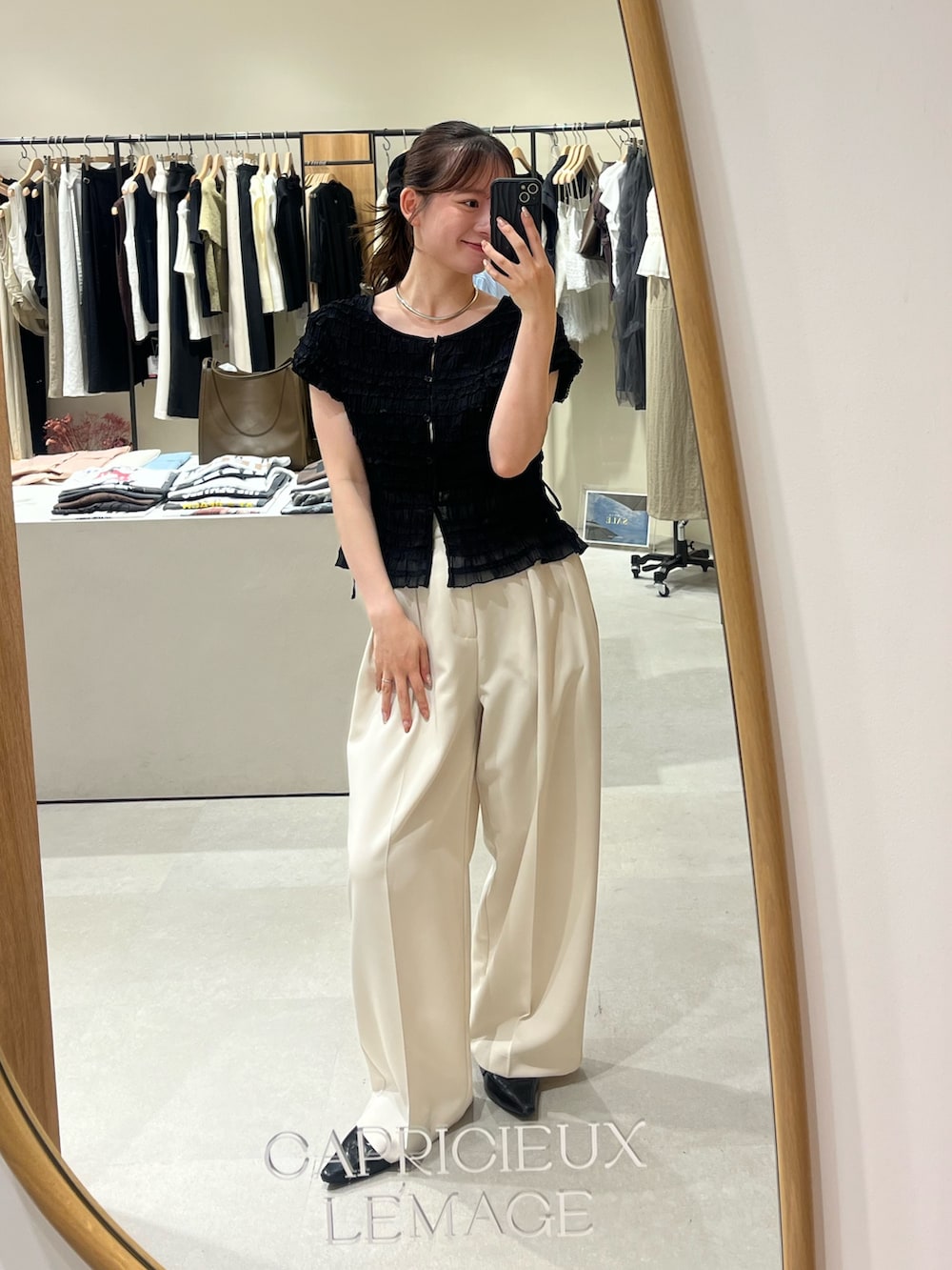 ブラック系のシャツ/ブラウス、ホワイト系のその他パンツ、ホワイト系のショルダーバッグを着用したレディースの夏コーディネートの2枚目の写真