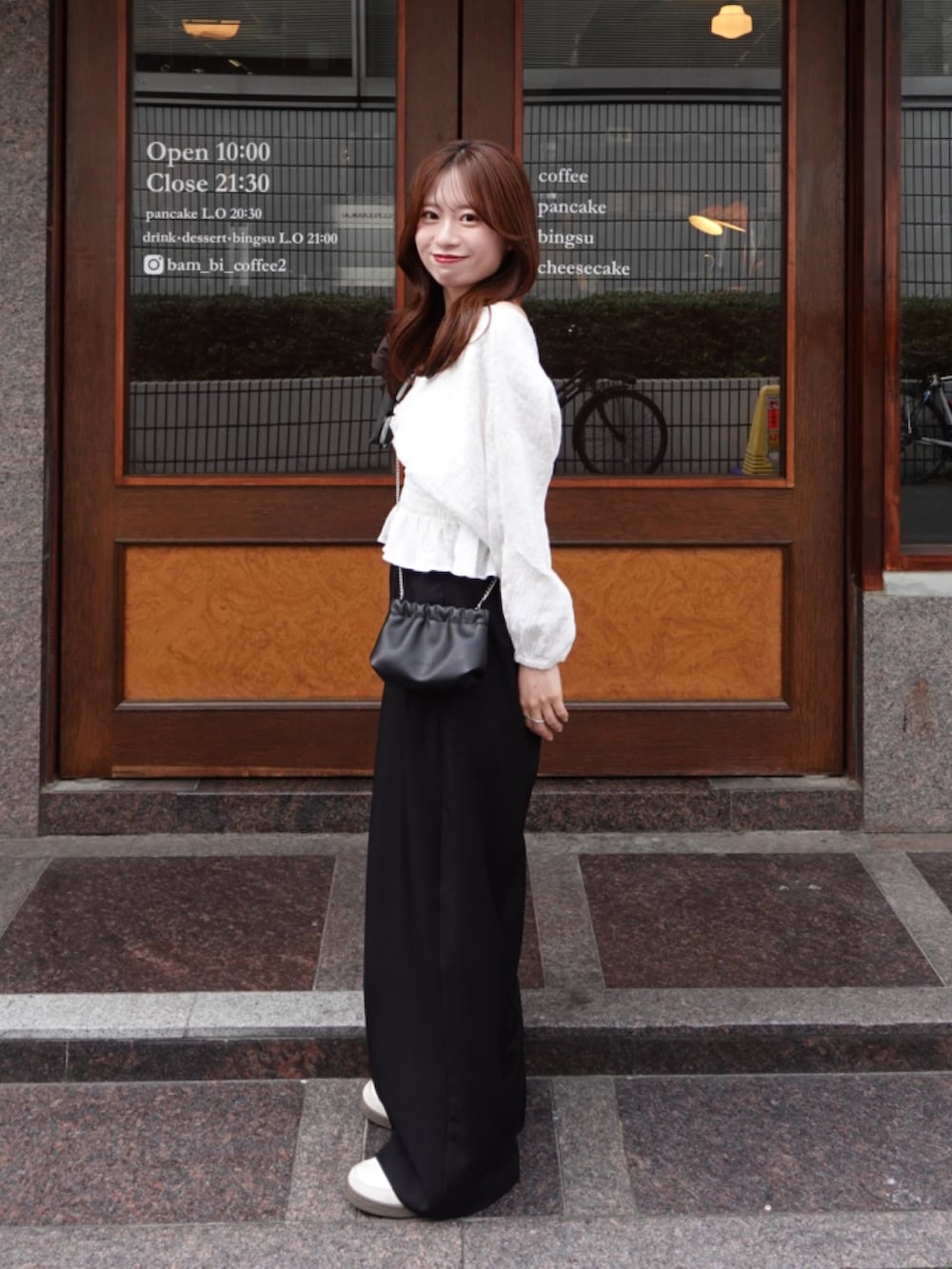 ホワイト系のシャツ/ブラウス、ブラック系のその他パンツ、ブラック系のショルダーバッグを着用したレディースの春コーディネートの2枚目の写真