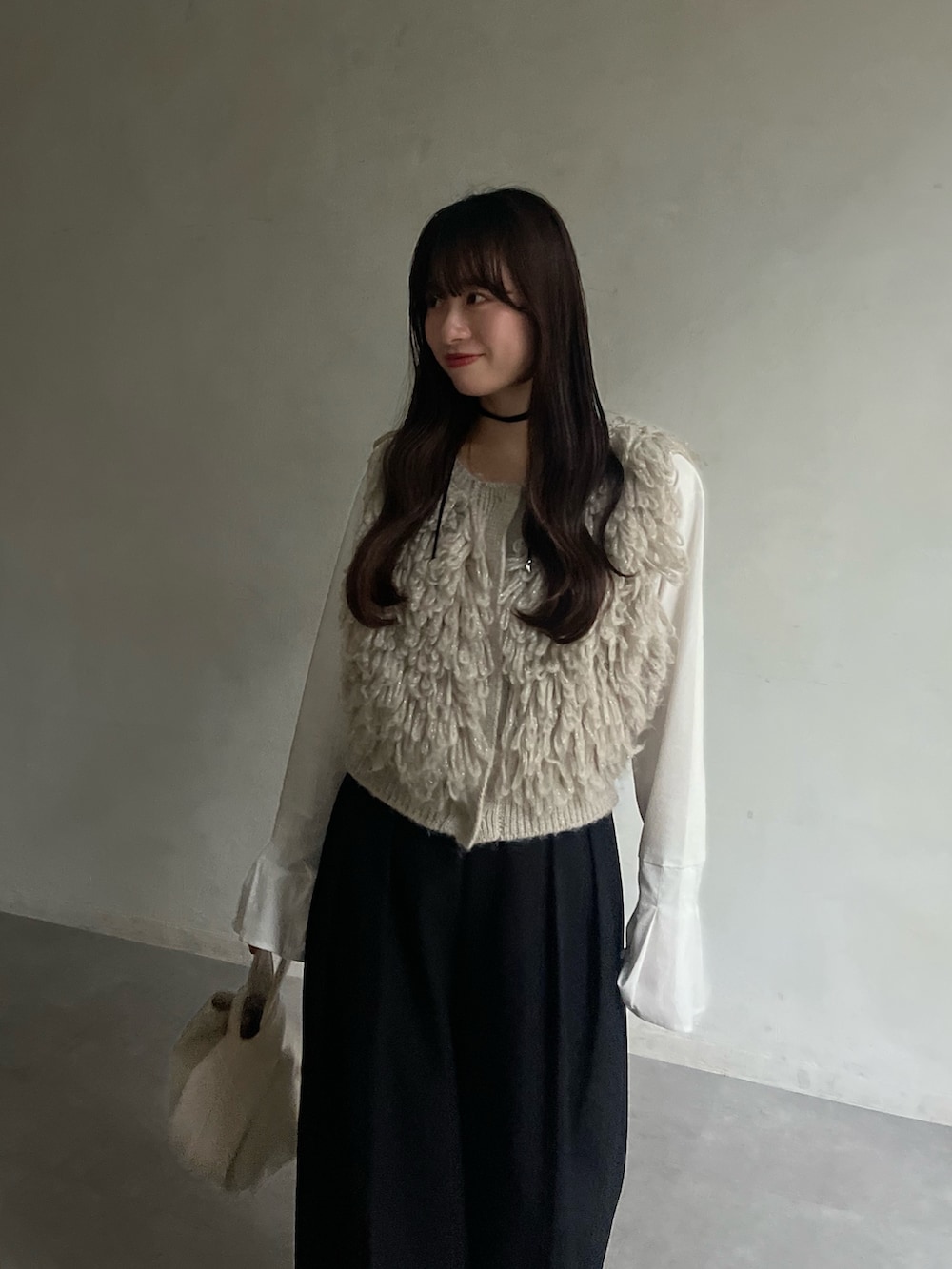 ホワイト系のTシャツ/カットソー、ベージュ系のベスト、ブラック系のその他パンツを着用したレディースの冬コーディネートの3枚目の写真