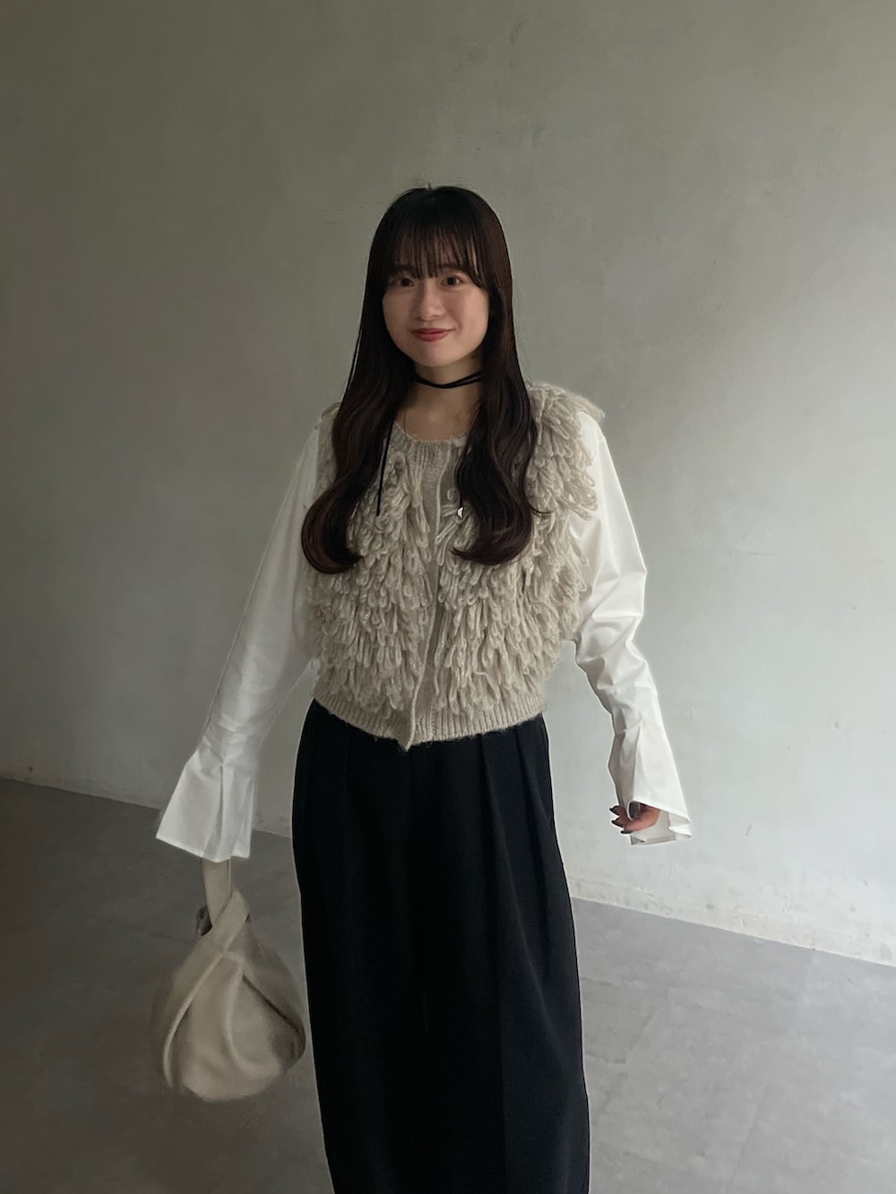 ホワイト系のTシャツ/カットソー、ベージュ系のベスト、ブラック系のその他パンツを着用したレディースの冬コーディネートの4枚目の写真