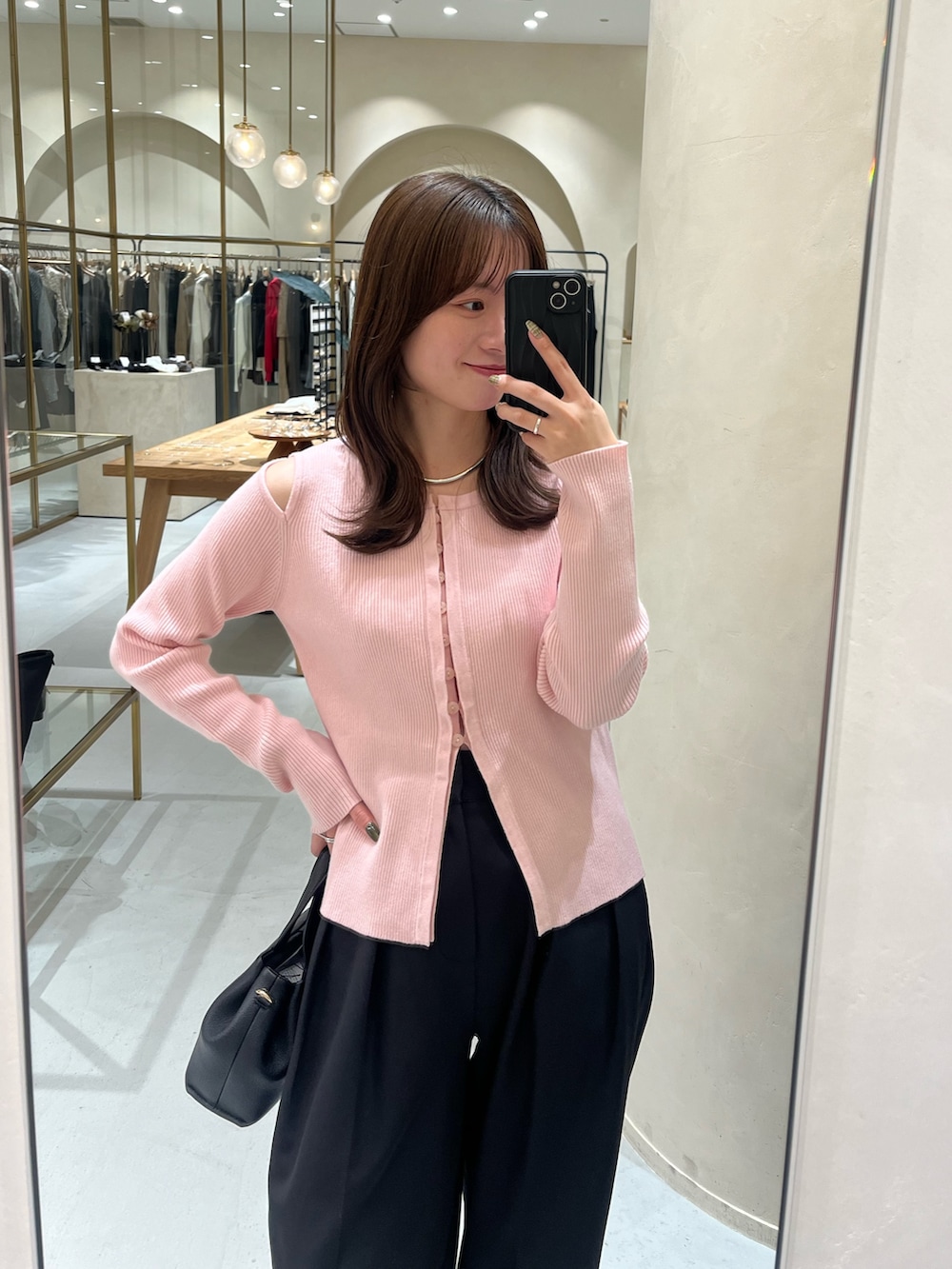 ピンク系のカーディガン/ボレロ、ブラック系のその他パンツ、ブラック系のショルダーバッグを着用したレディースの冬コーディネートの2枚目の写真