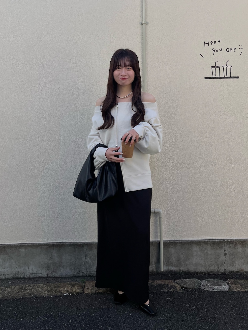 ホワイト系のTシャツ/カットソー、ブラック系のスカート、ブラック系のショルダーバッグを着用したレディースの春コーディネートの2枚目の写真