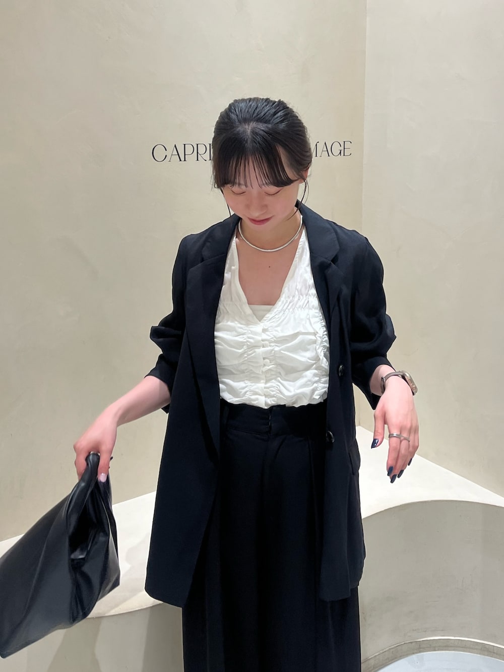 ブラック系のその他パンツ、ブラック系のテーラードジャケット、ホワイト系のシャツ/ブラウスを着用したレディースの春コーディネートの2枚目の写真