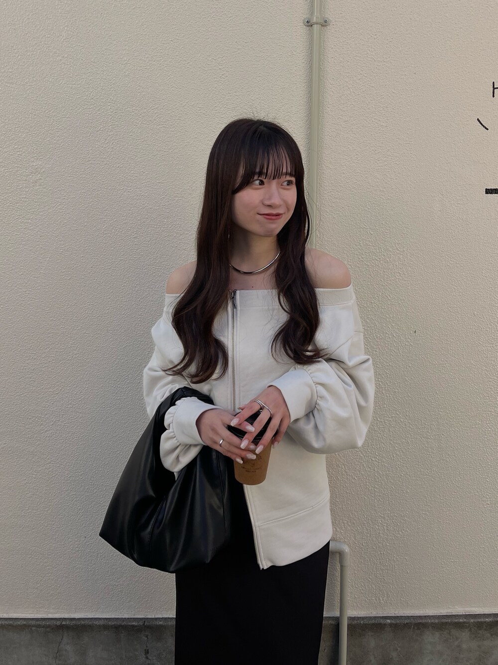 ホワイト系のTシャツ/カットソー、ブラック系のスカート、ブラック系のショルダーバッグを着用したレディースの春コーディネートの3枚目の写真