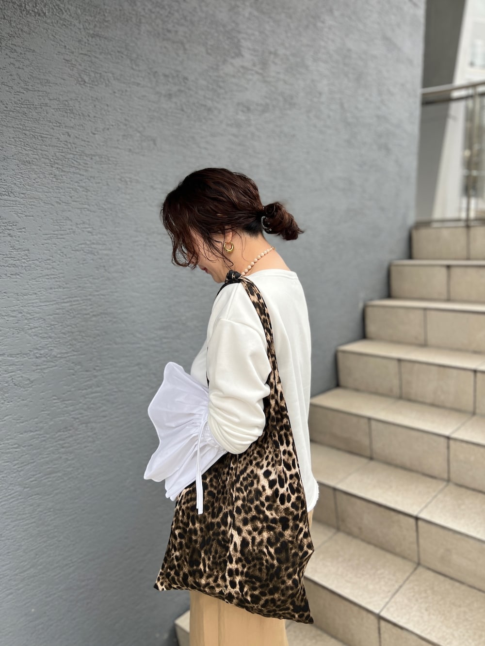 ホワイト系のTシャツ/カットソー、ベージュ系のその他パンツ、その他のエコバッグ/サブバッグを着用したレディースの春コーディネートの3枚目の写真