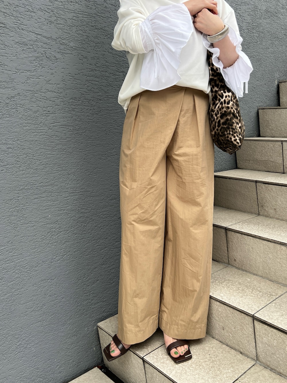 ホワイト系のTシャツ/カットソー、ベージュ系のその他パンツ、その他のエコバッグ/サブバッグを着用したレディースの春コーディネートの4枚目の写真