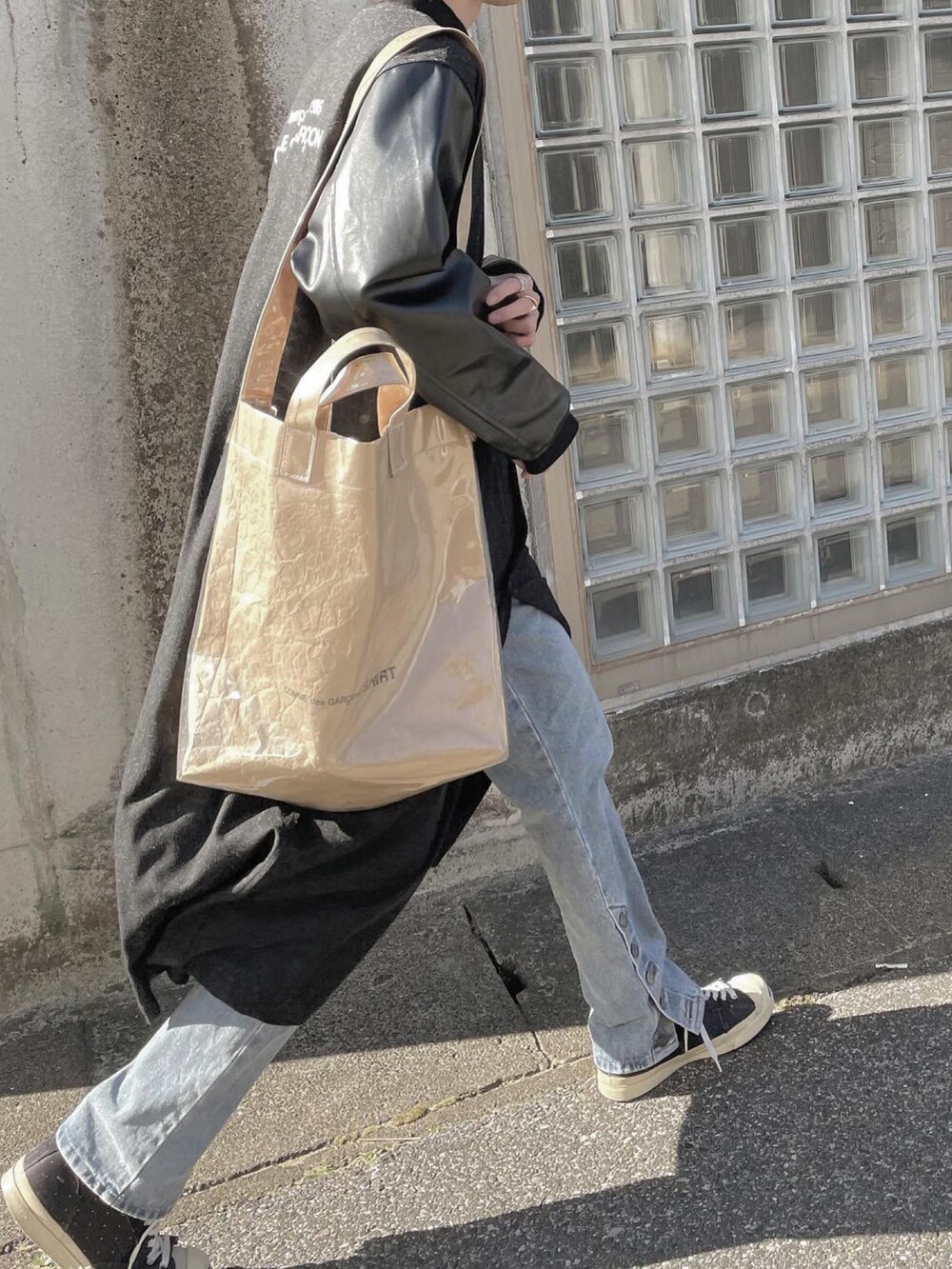 ブラック系のスニーカー、ブラック系のチェスターコートを着用したメンズの冬コーディネートの2枚目の写真