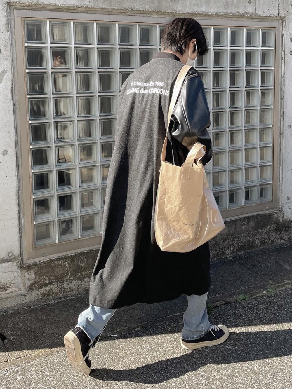 ブラック系のスニーカー、ブラック系のチェスターコートを着用したメンズの冬コーディネートの3枚目の写真