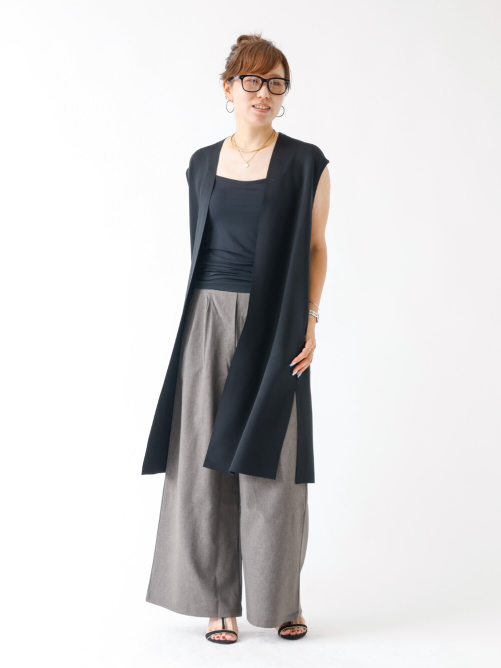 ブラック系のベスト、グレー系のその他パンツを着用したレディースの夏コーディネートの2枚目の写真