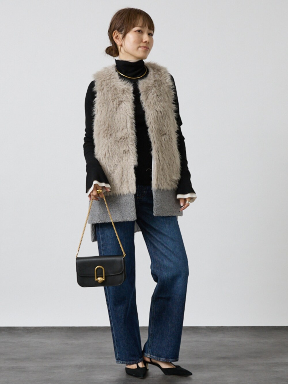 グレー系のベストを着用したレディースの秋コーディネートの2枚目の写真