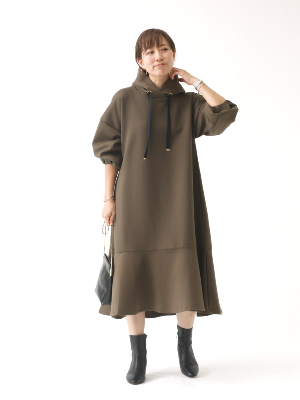 グリーン系のワンピースを着用したレディースの秋コーディネートの2枚目の写真