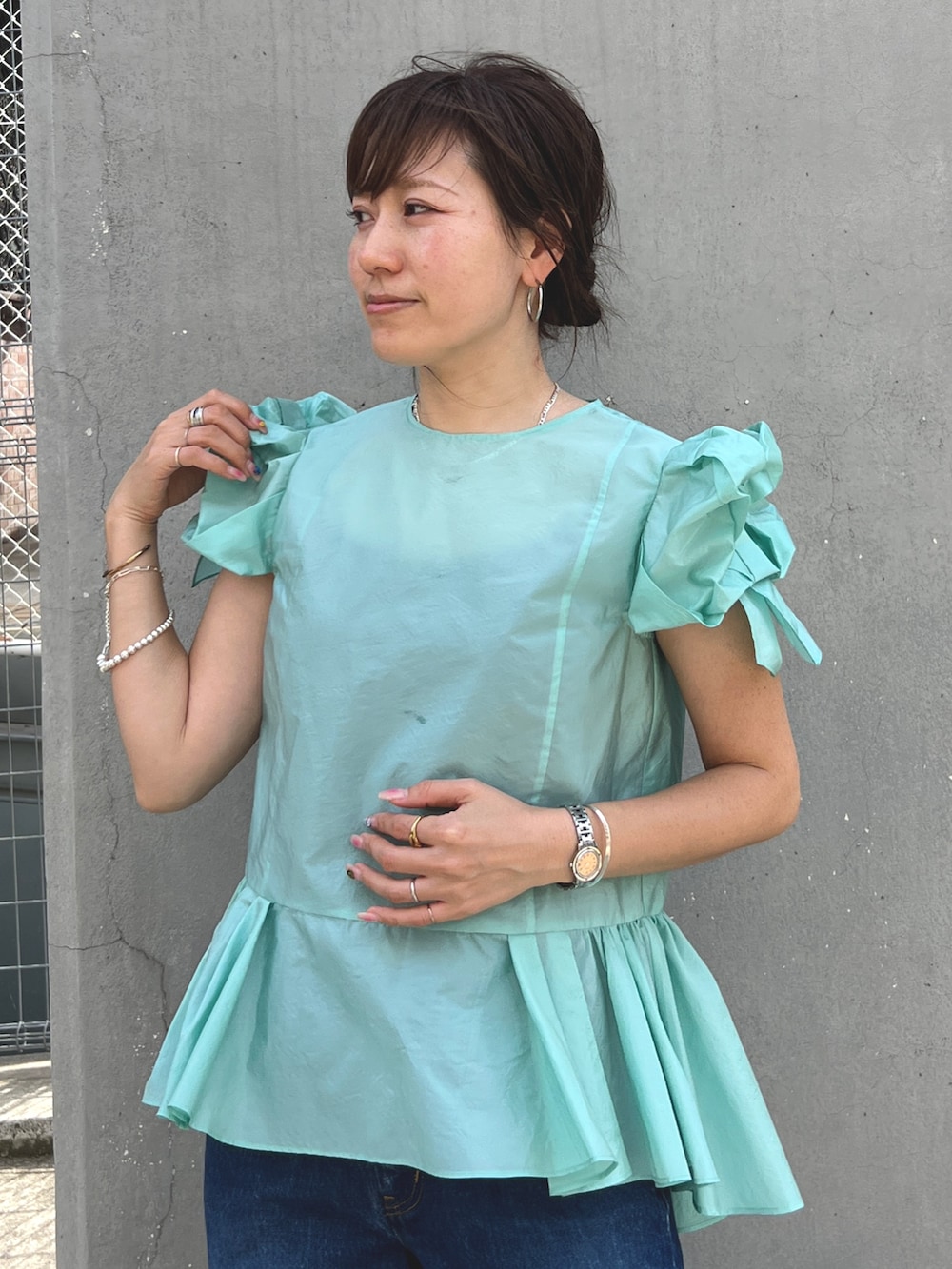 グリーン系のシャツ/ブラウス、ブルー系のデニムパンツを着用したレディースの秋コーディネートの2枚目の写真