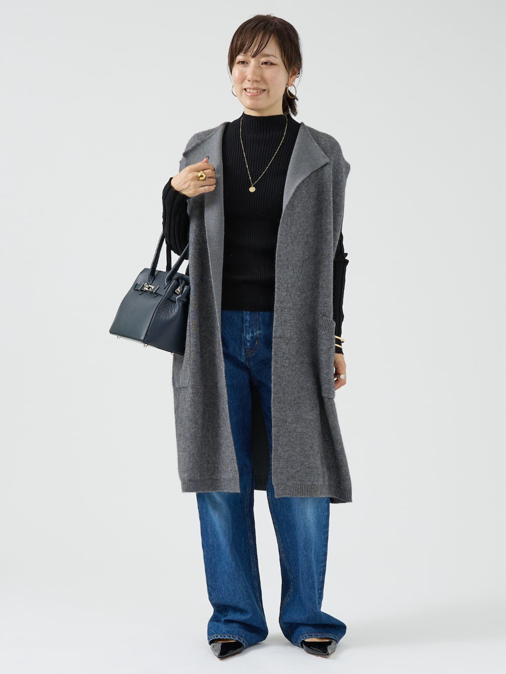 グレー系のベストを着用したレディースの秋コーディネートの3枚目の写真