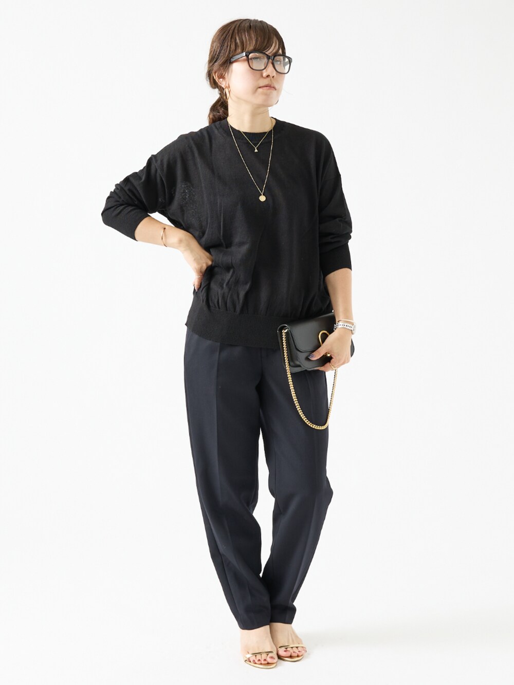 ブラック系のニット/セーター、ブルー系のその他パンツを着用したレディースの夏コーディネートの2枚目の写真