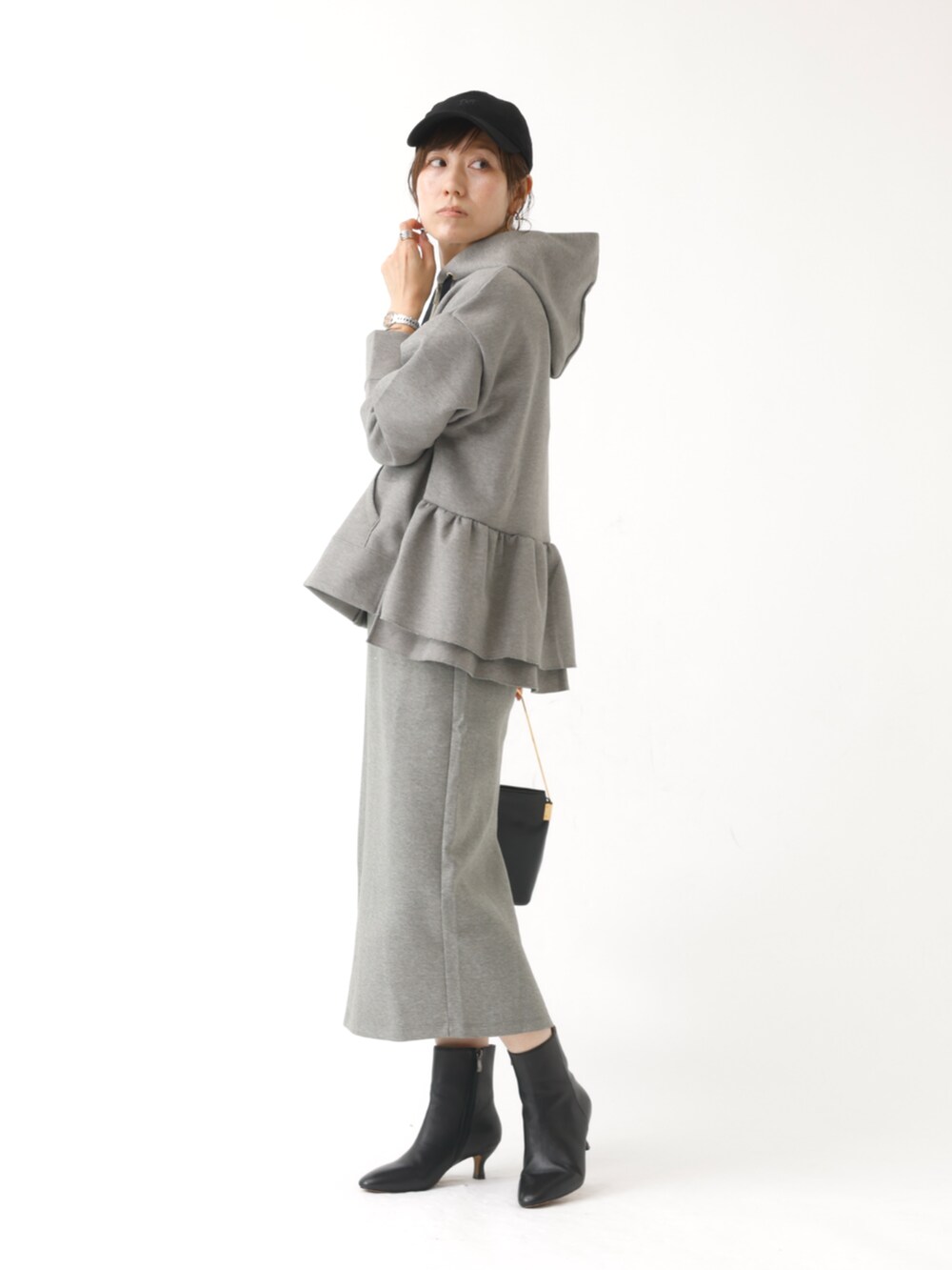 グレー系のパーカー、グレー系のスカートを着用したレディースの秋コーディネートの3枚目の写真