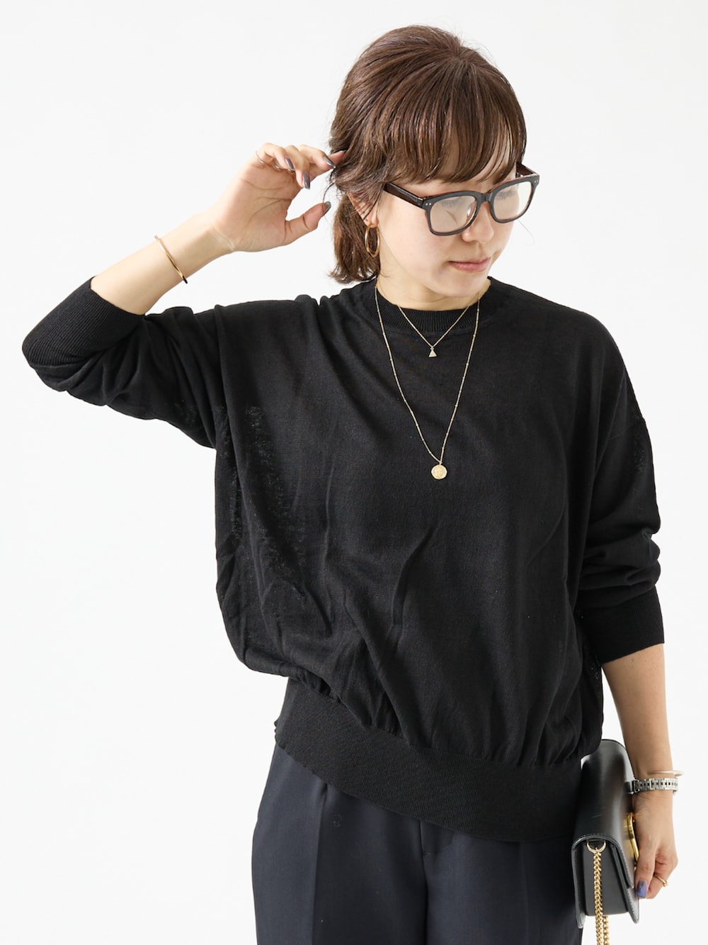 ブラック系のニット/セーター、ブルー系のその他パンツを着用したレディースの夏コーディネートの3枚目の写真