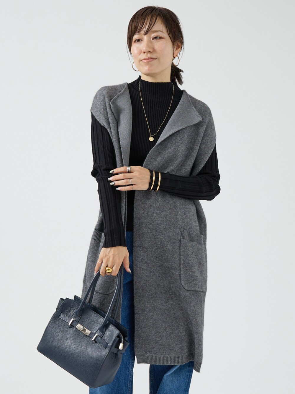 グレー系のベストを着用したレディースの秋コーディネートの2枚目の写真