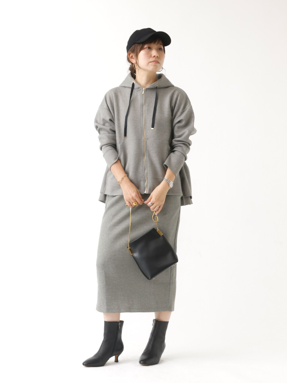 グレー系のパーカー、グレー系のスカートを着用したレディースの秋コーディネートの2枚目の写真