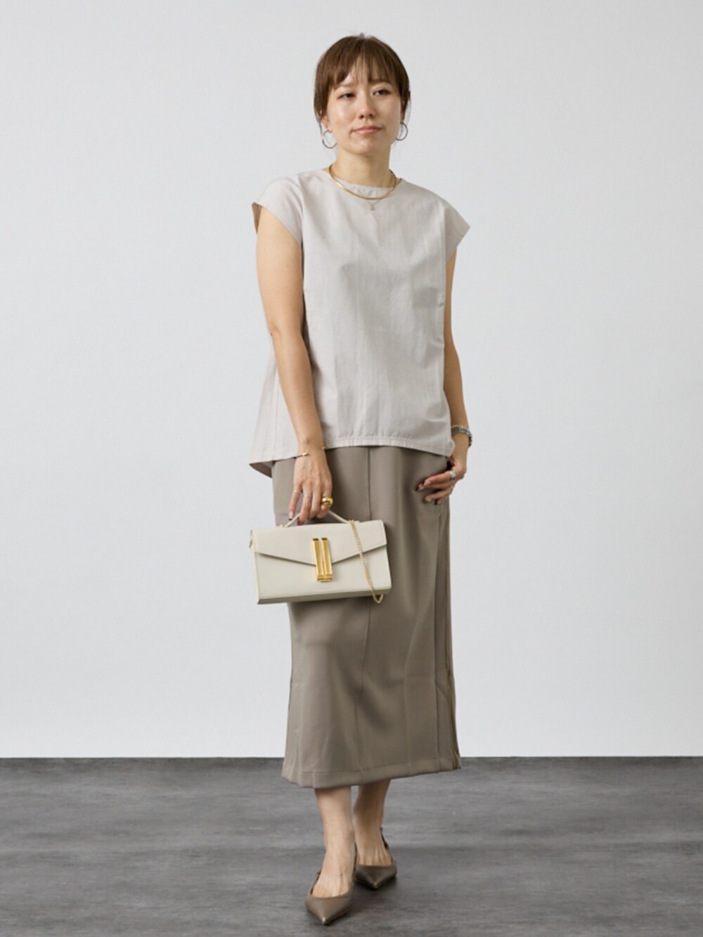 グレー系のシャツ/ブラウス、ベージュ系のスカートを着用したレディースの秋コーディネートの2枚目の写真