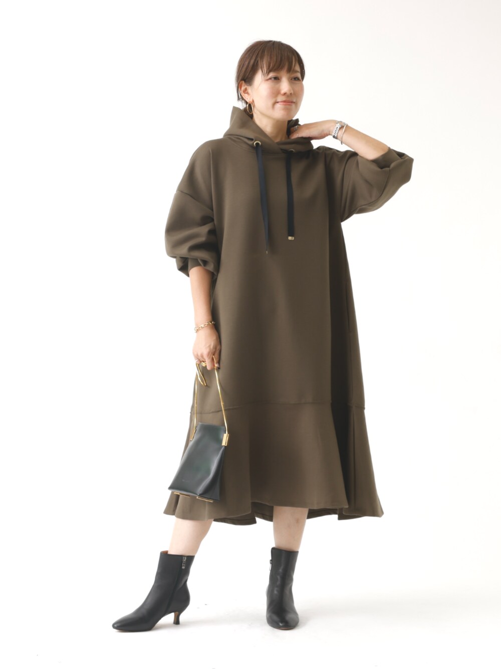 グリーン系のワンピースを着用したレディースの秋コーディネートの3枚目の写真