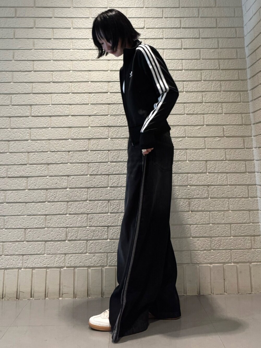 ブラック系のジャージ、ホワイト系のタンクトップ、ブラック系のデニムパンツを着用したレディースの夏コーディネートの2枚目の写真