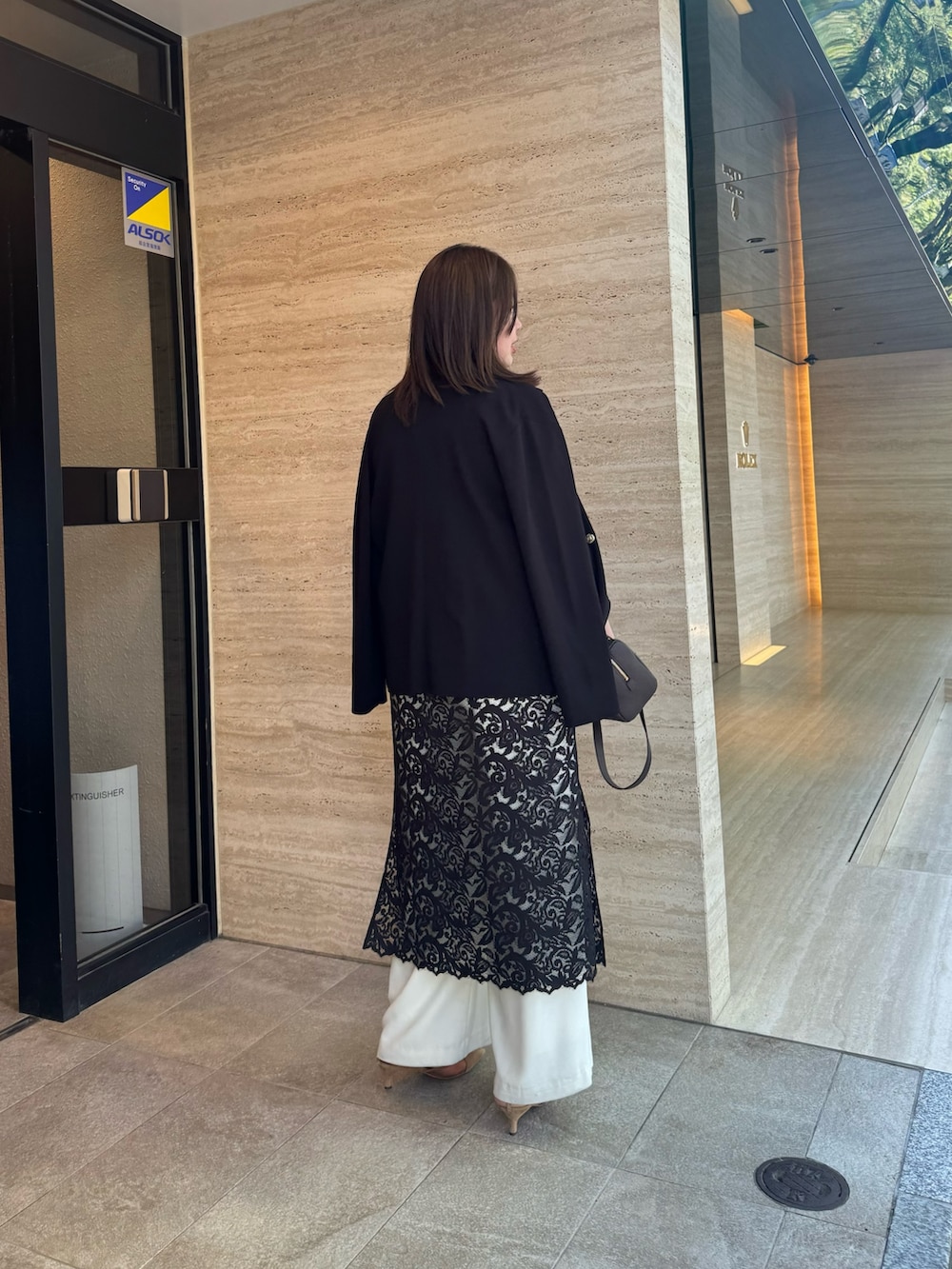 ブラック系のワンピース、ブラウン系のショルダーバッグ、ブラック系のテーラードジャケットを着用したレディースの夏コーディネートの3枚目の写真