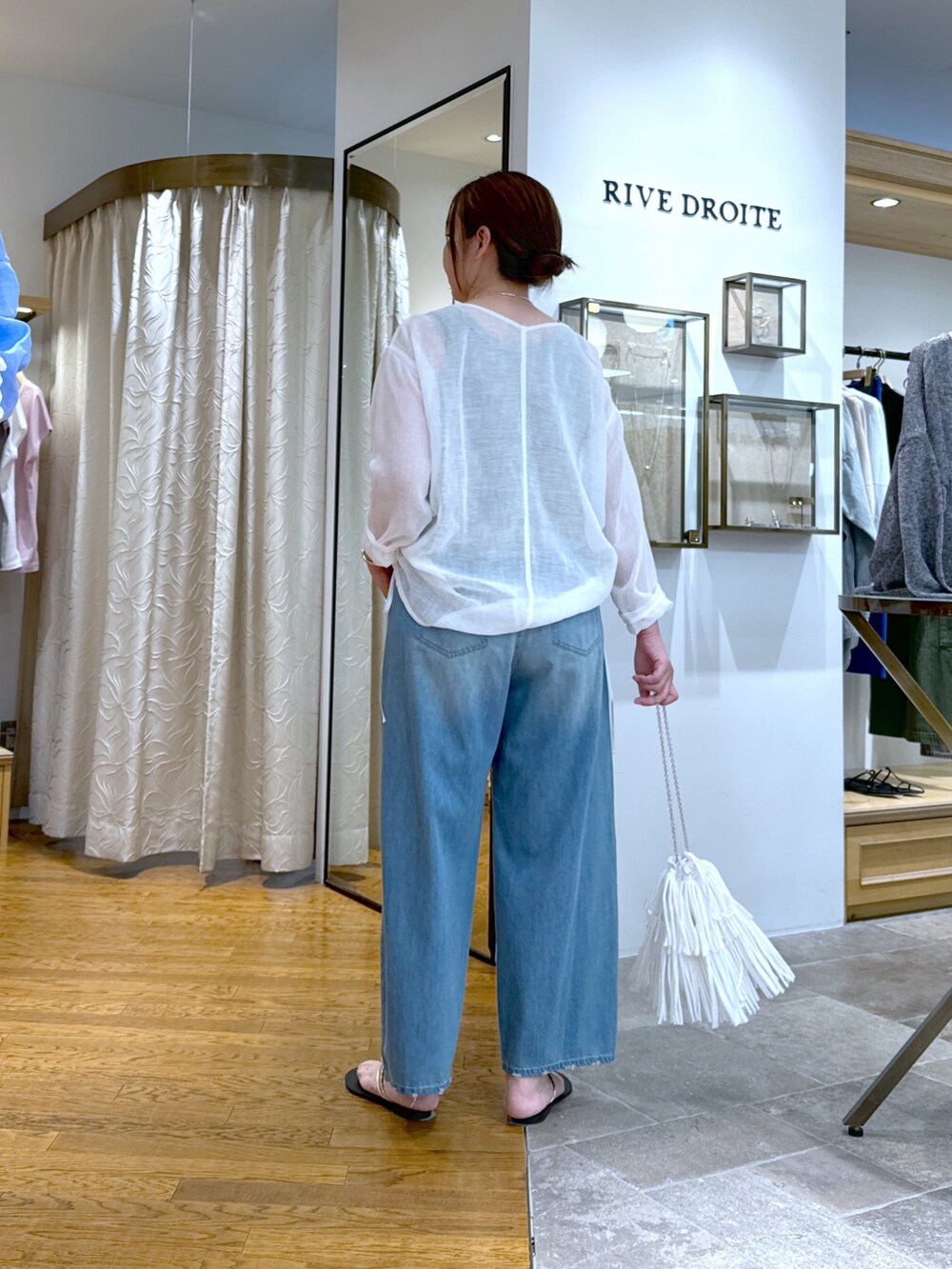 ホワイト系のシャツ/ブラウス、ブルー系のデニムパンツ、ホワイト系のハンドバッグを着用したレディースの夏コーディネートの3枚目の写真