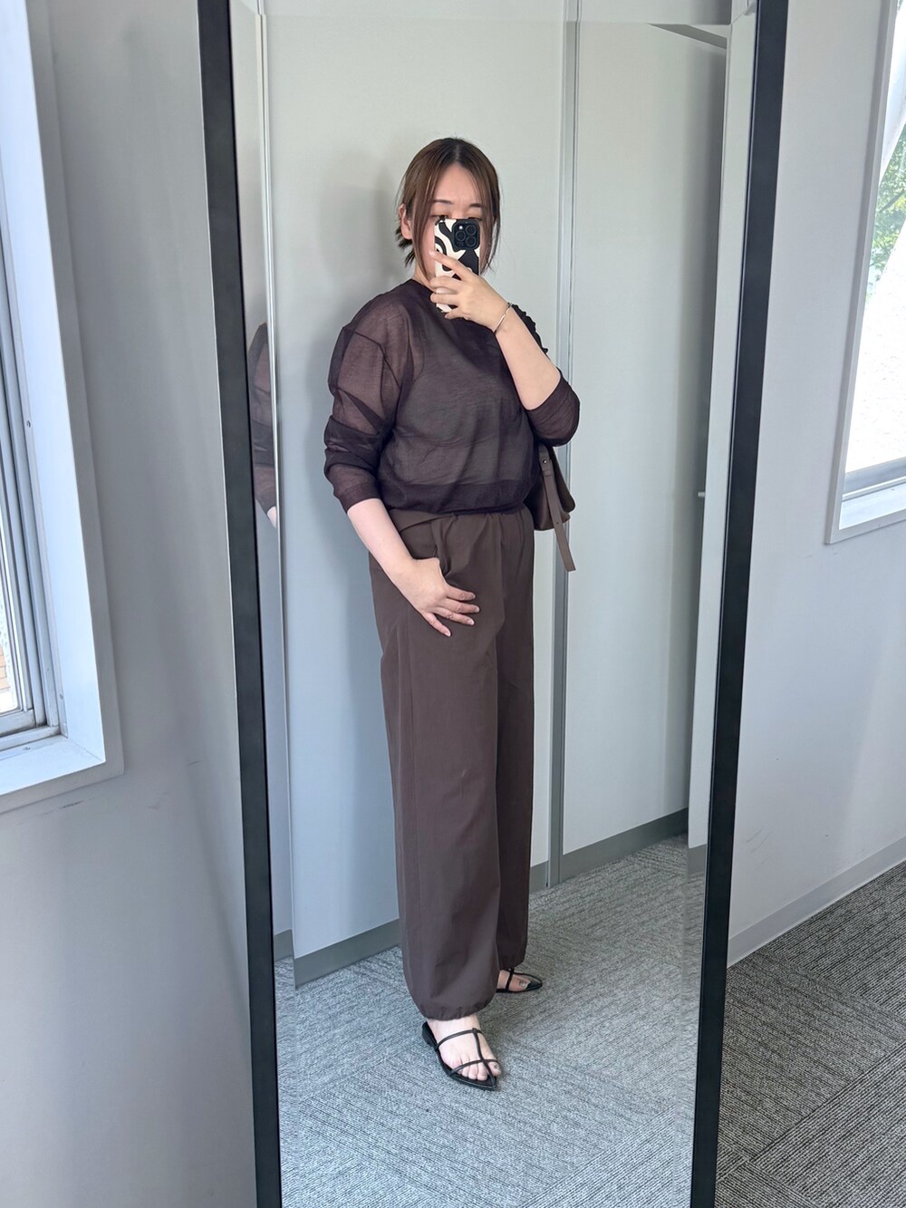 レッド系のニット/セーター、ブラウン系のその他パンツ、ブラウン系のショルダーバッグを着用したレディースの夏コーディネートの2枚目の写真