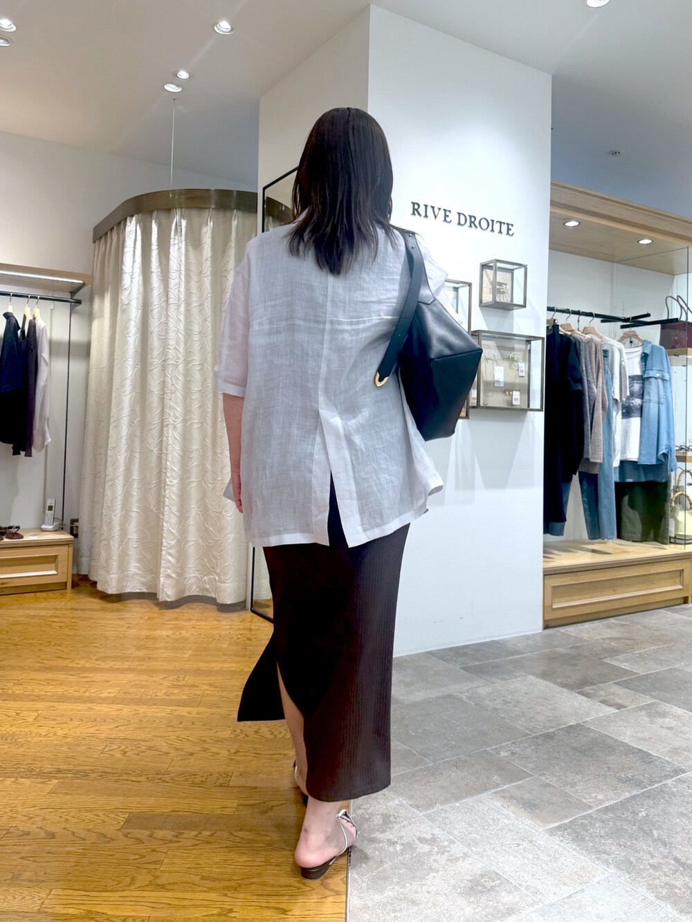 ブルー系のテーラードジャケット、ブラウン系のワンピース、ブラック系のボディバッグ/ウエストポーチを着用したレディースの夏コーディネートの3枚目の写真