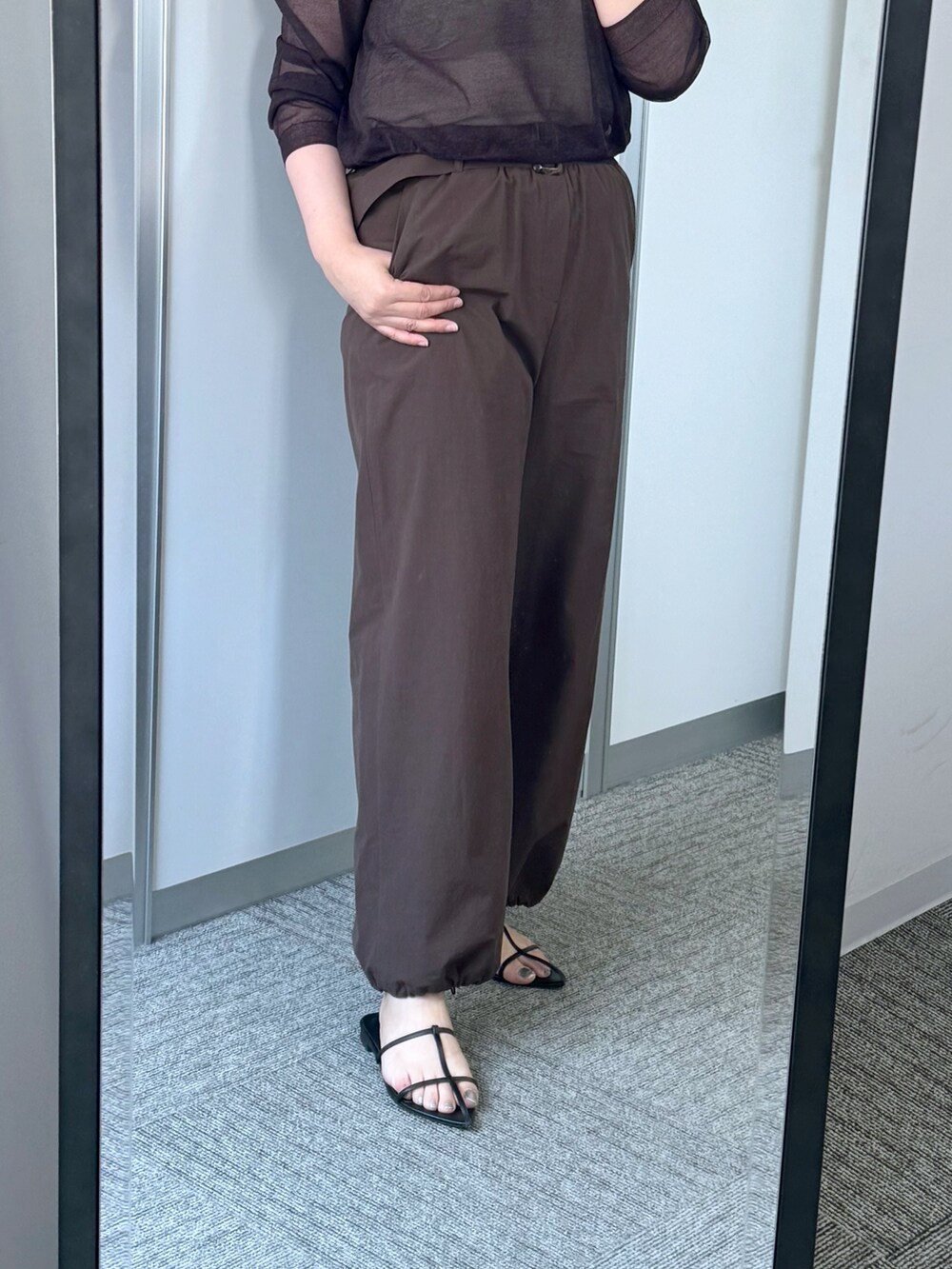 レッド系のニット/セーター、ブラウン系のその他パンツ、ブラウン系のショルダーバッグを着用したレディースの夏コーディネートの3枚目の写真