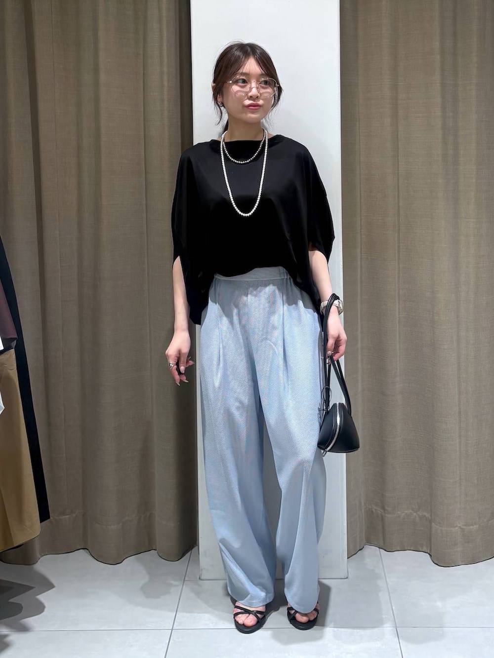 ブラック系のTシャツ/カットソー、ブラック系のハンドバッグ、ブルー系のその他パンツを着用したレディースの春コーディネートの6枚目の写真