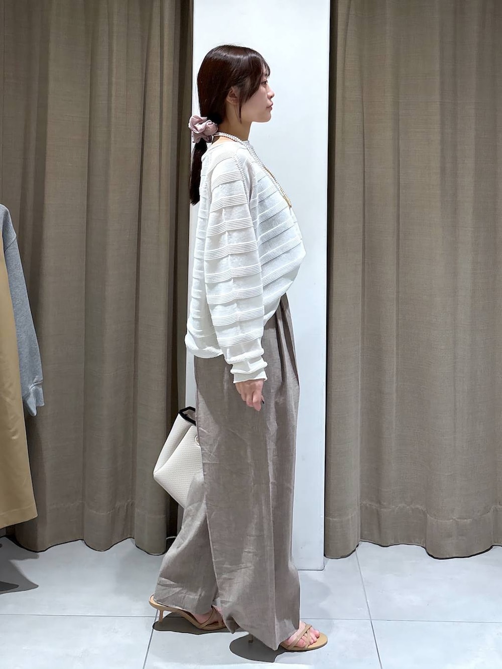 ブラック系のタンクトップ、ホワイト系のニット/セーター、ベージュ系のその他パンツを着用したレディースの春コーディネートの3枚目の写真