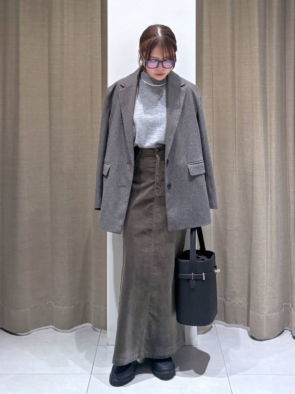 ブラウン系のテーラードジャケット、グレー系のニット/セーター、ブラウン系のスカートを着用したレディースの秋コーディネートの2枚目の写真