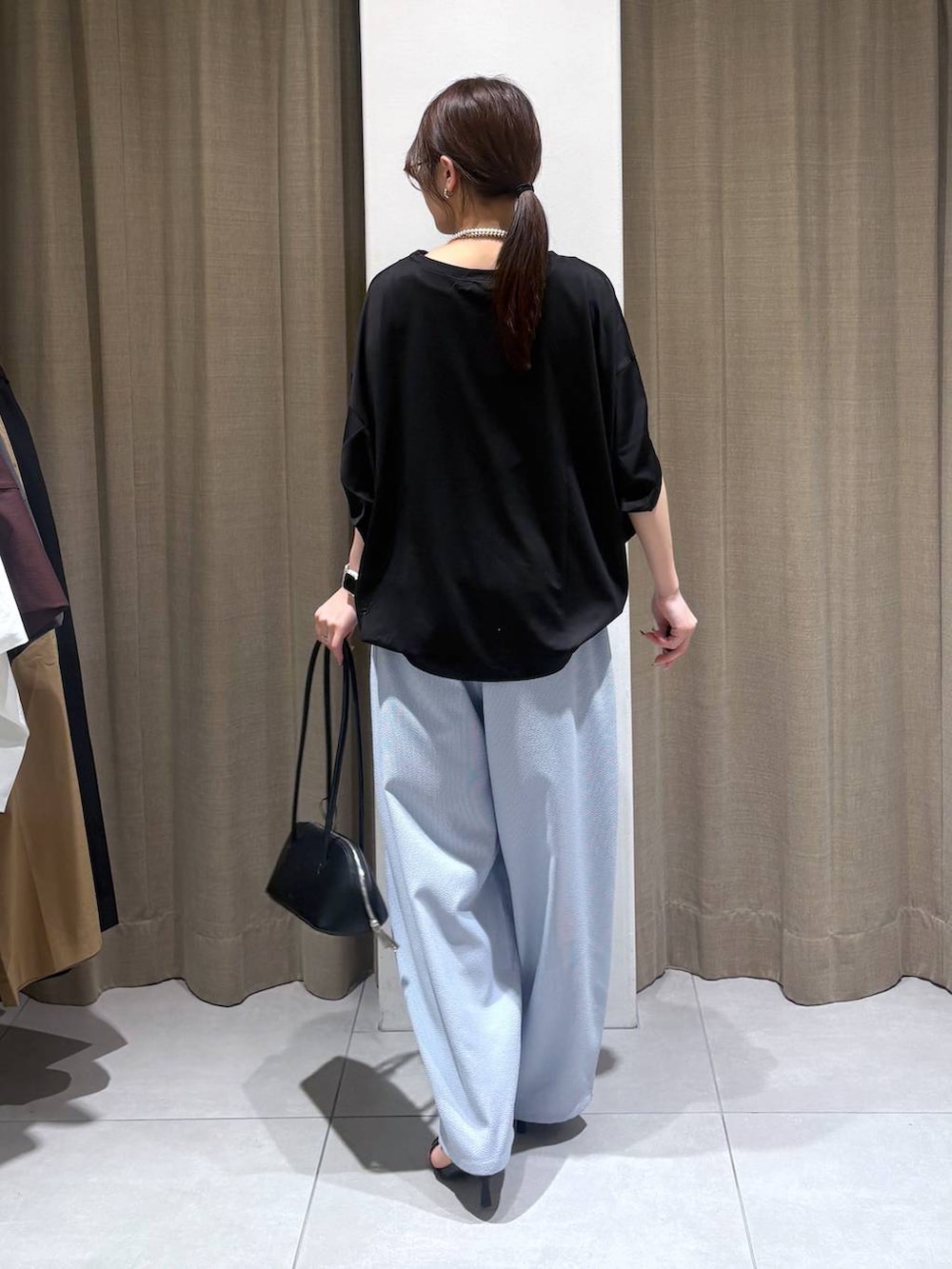 ブラック系のTシャツ/カットソー、ブラック系のハンドバッグ、ブルー系のその他パンツを着用したレディースの春コーディネートの3枚目の写真