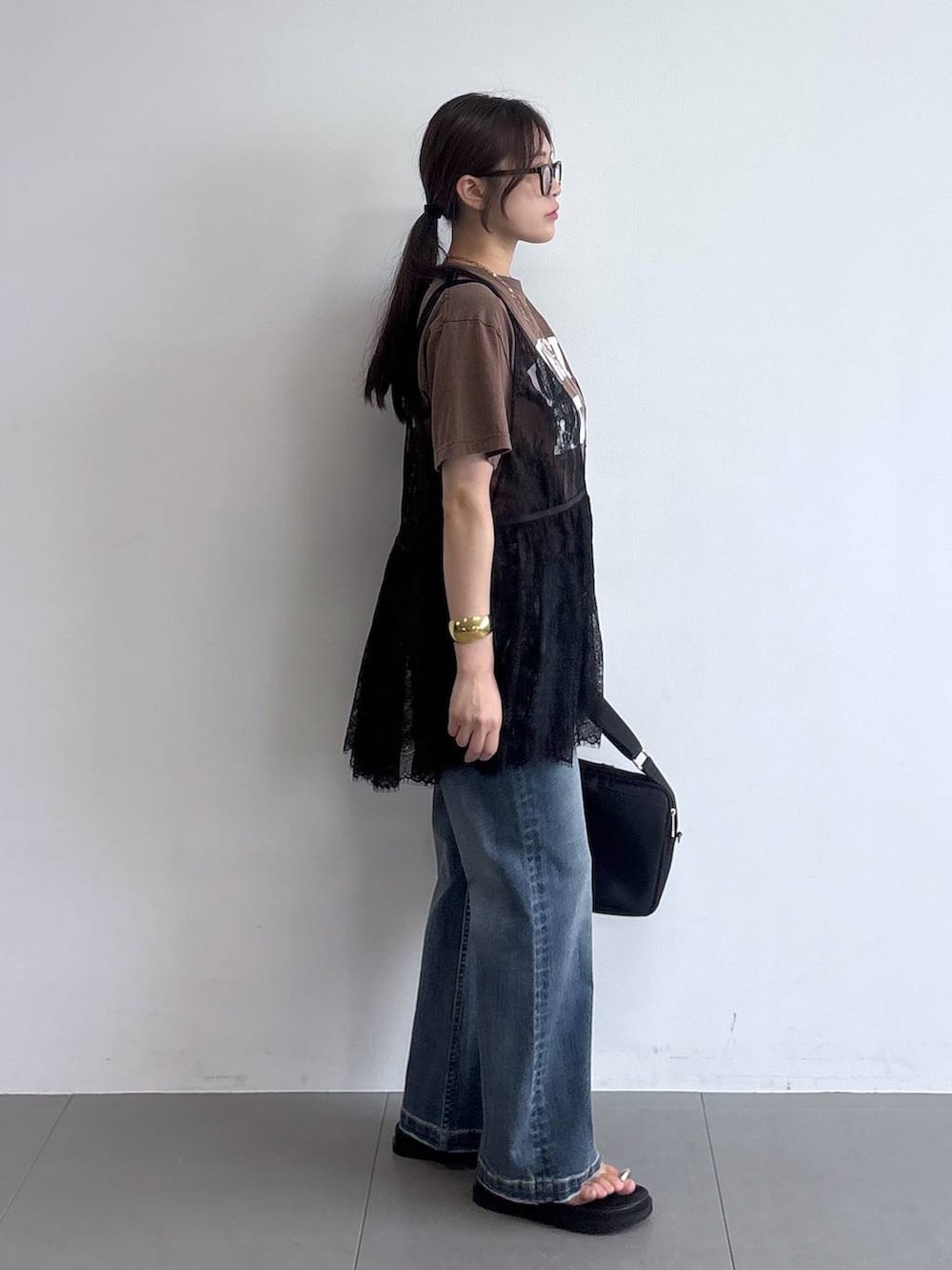 ブラック系のサンダル、ブラック系のショルダーバッグ、ブラウン系のTシャツ/カットソーを着用したレディースの夏コーディネートの2枚目の写真