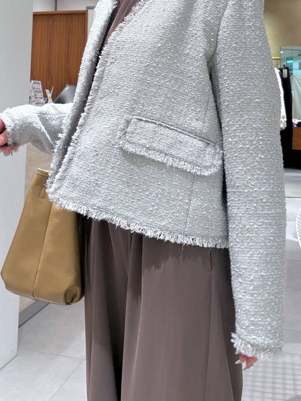 グリーン系のつなぎ/オールインワン、グレー系のノーカラージャケット、イエロー系のトートバッグを着用したレディースの冬コーディネートの4枚目の写真