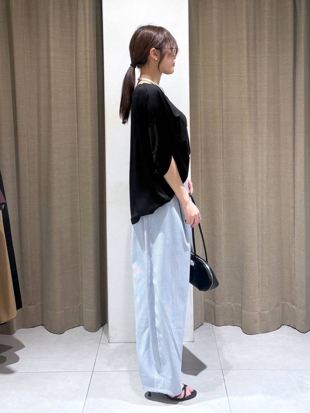 ブラック系のTシャツ/カットソー、ブラック系のハンドバッグ、ブルー系のその他パンツを着用したレディースの春コーディネートの2枚目の写真