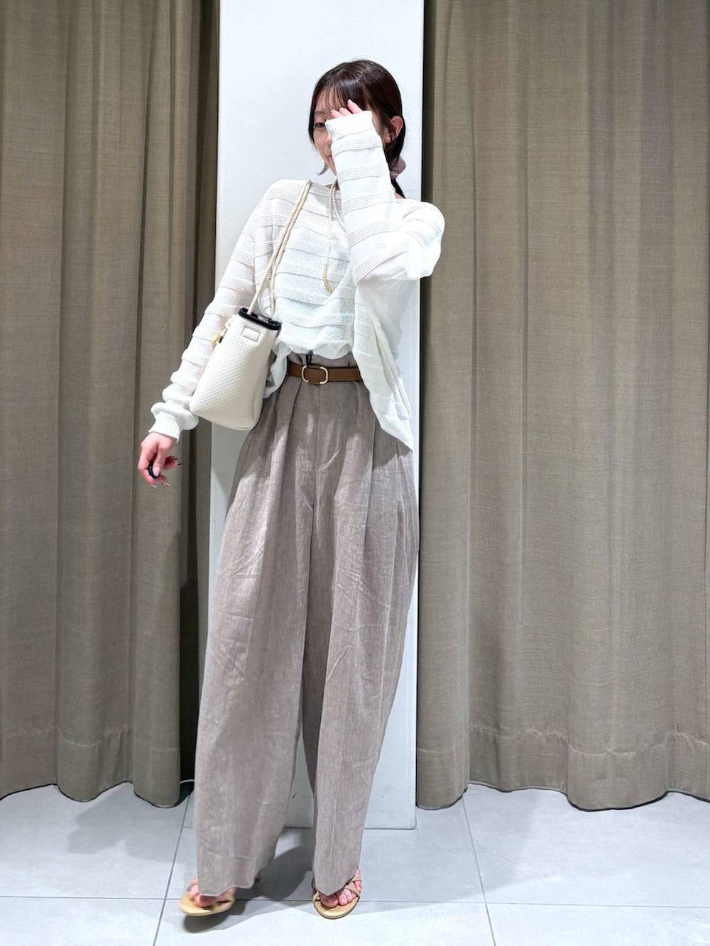 ブラック系のタンクトップ、ホワイト系のニット/セーター、ベージュ系のその他パンツを着用したレディースの春コーディネートの2枚目の写真