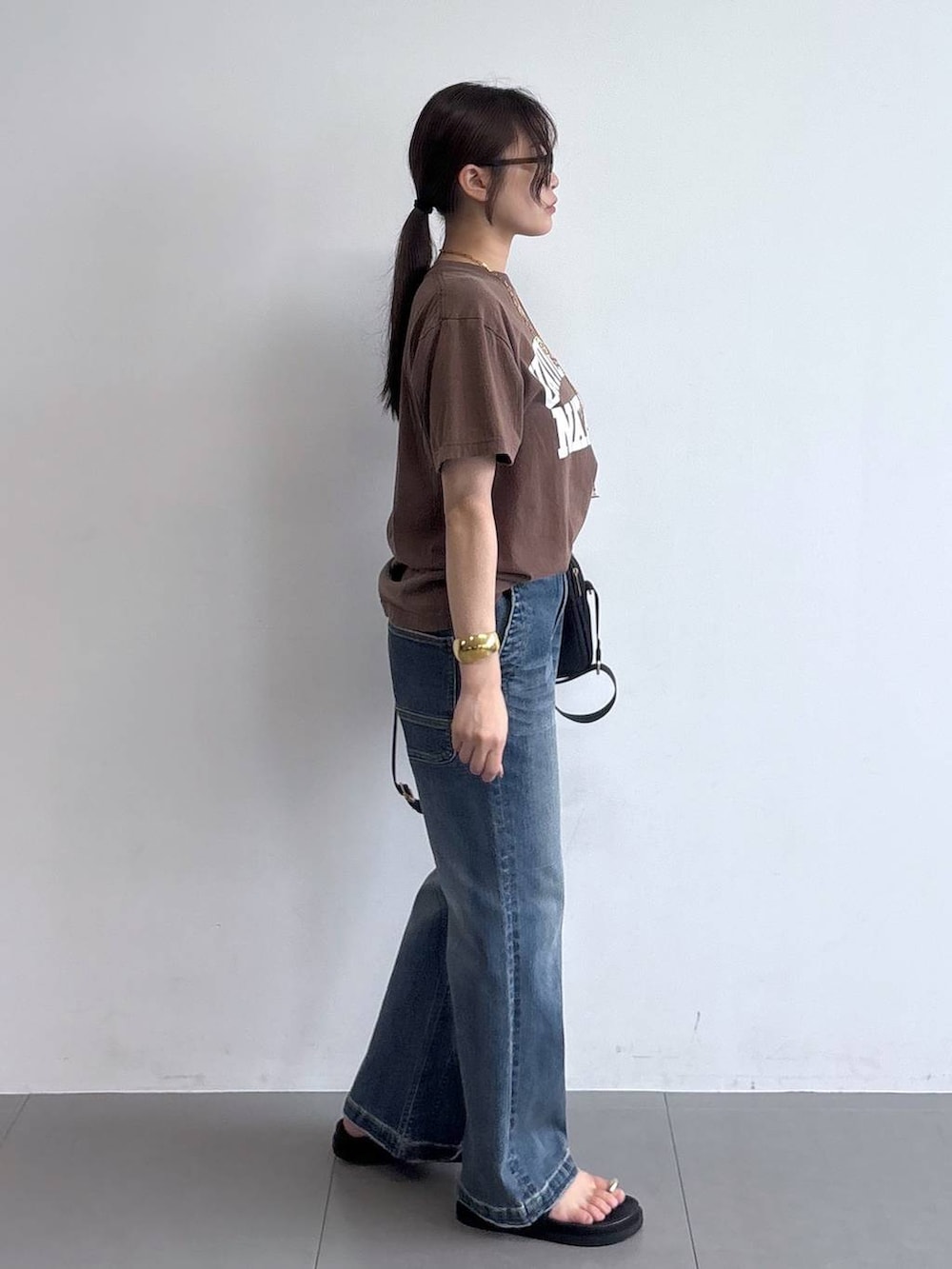 ブラック系のサンダル、ブラック系のショルダーバッグ、ブラウン系のTシャツ/カットソーを着用したレディースの夏コーディネートの6枚目の写真