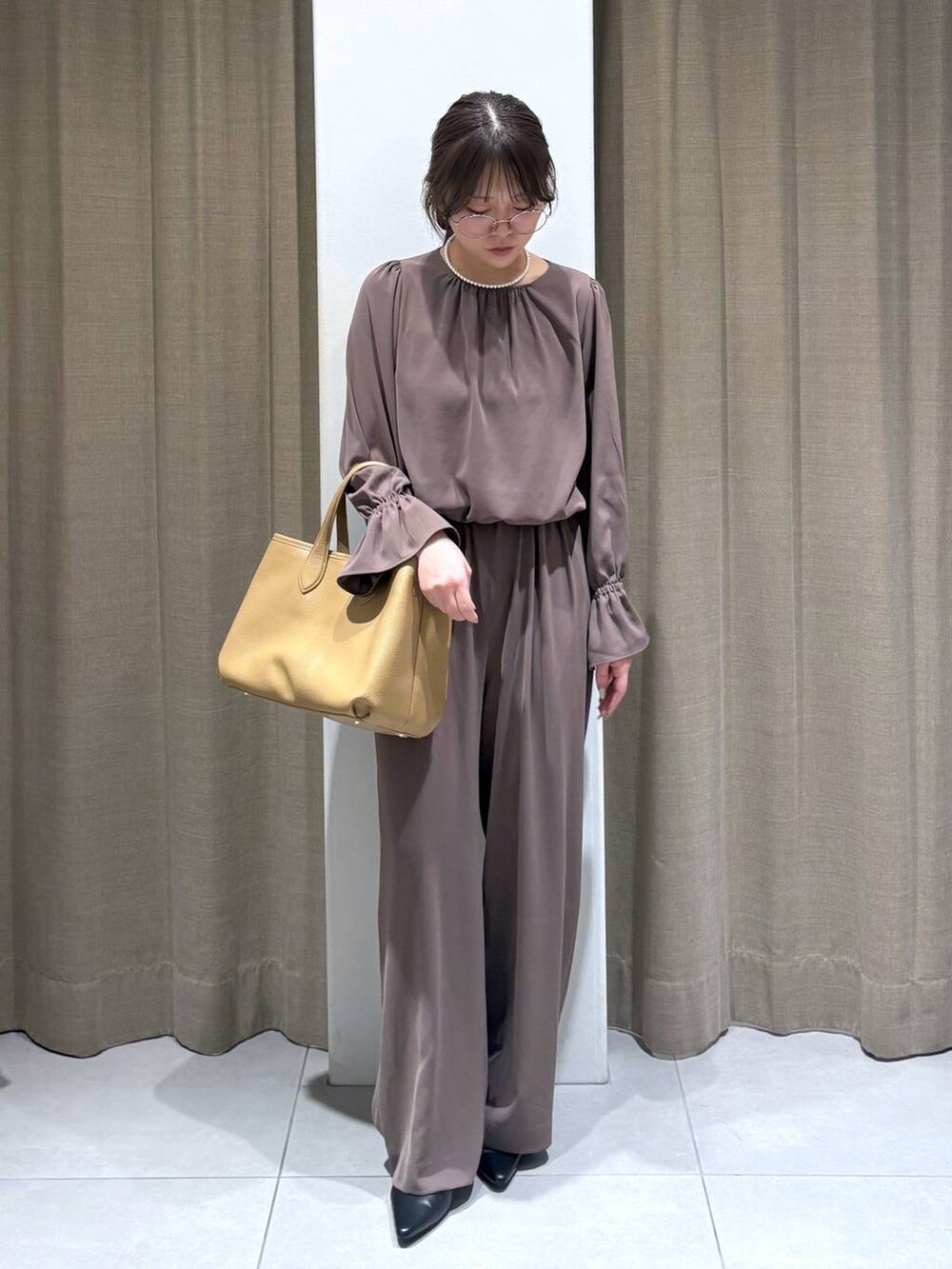 グリーン系のつなぎ/オールインワン、グレー系のノーカラージャケット、イエロー系のトートバッグを着用したレディースの冬コーディネートの5枚目の写真