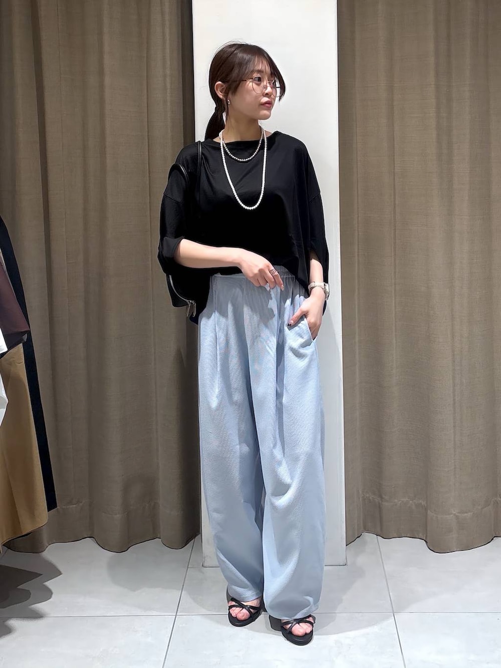 ブラック系のTシャツ/カットソー、ブラック系のハンドバッグ、ブルー系のその他パンツを着用したレディースの春コーディネートの4枚目の写真