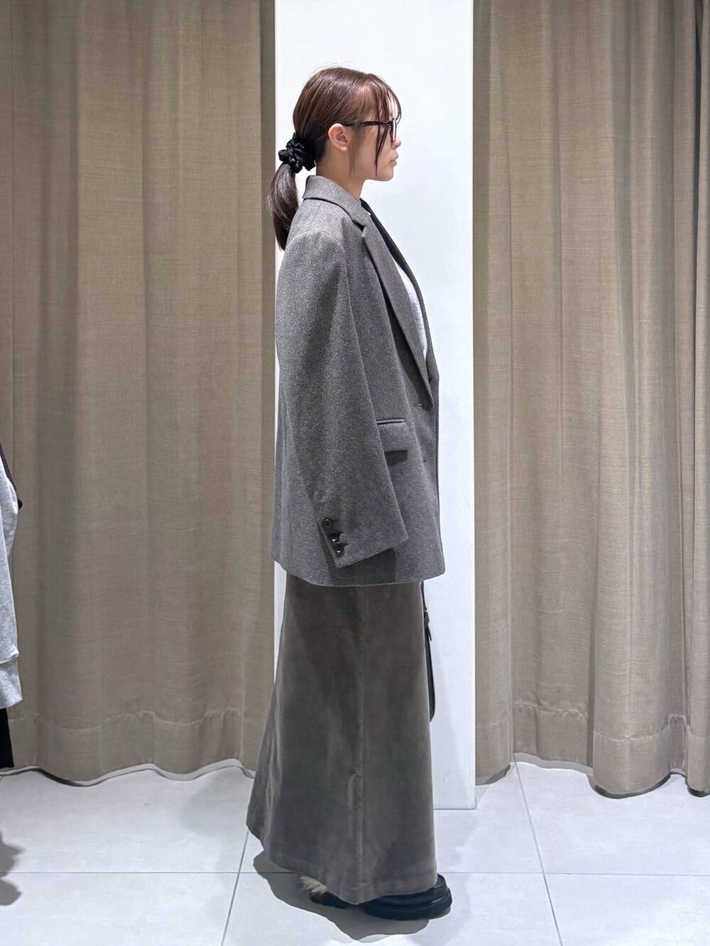 ブラウン系のテーラードジャケット、グレー系のニット/セーター、ブラウン系のスカートを着用したレディースの秋コーディネートの3枚目の写真