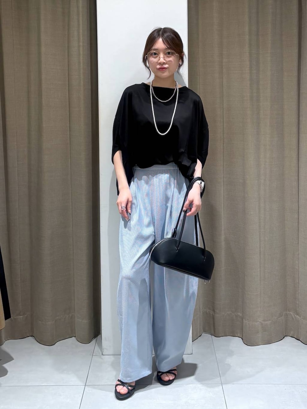 ブラック系のTシャツ/カットソー、ブラック系のハンドバッグ、ブルー系のその他パンツを着用したレディースの春コーディネートの5枚目の写真